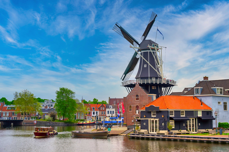 A windmill along the canals in Haarlem, Netherlands on a clear day.