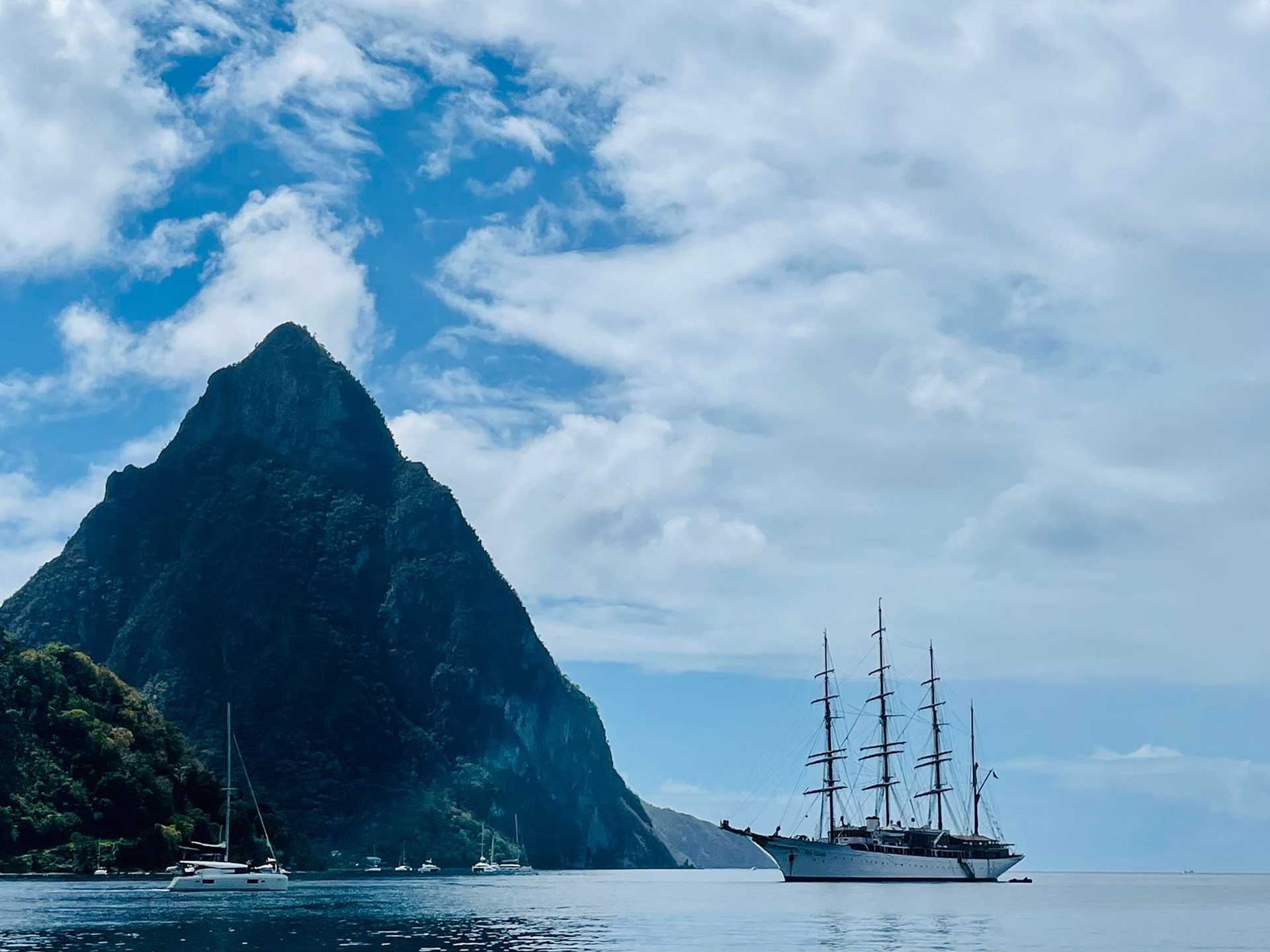 Sea Cloud anchored in front of large cliff