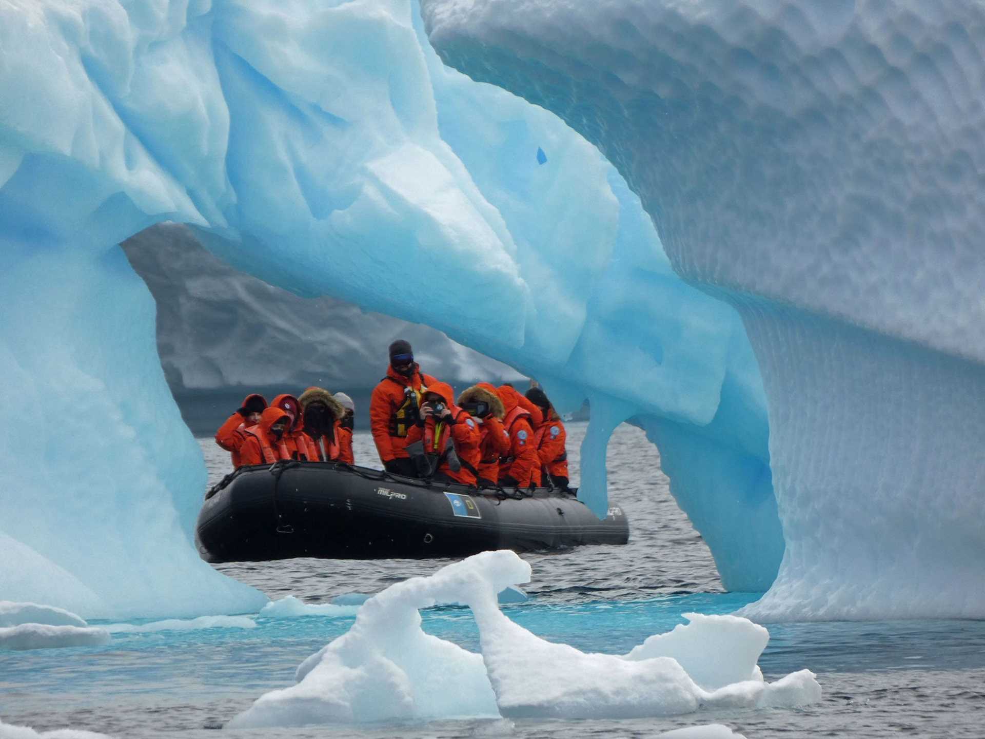 people in a zodiac looking through a hole in ice