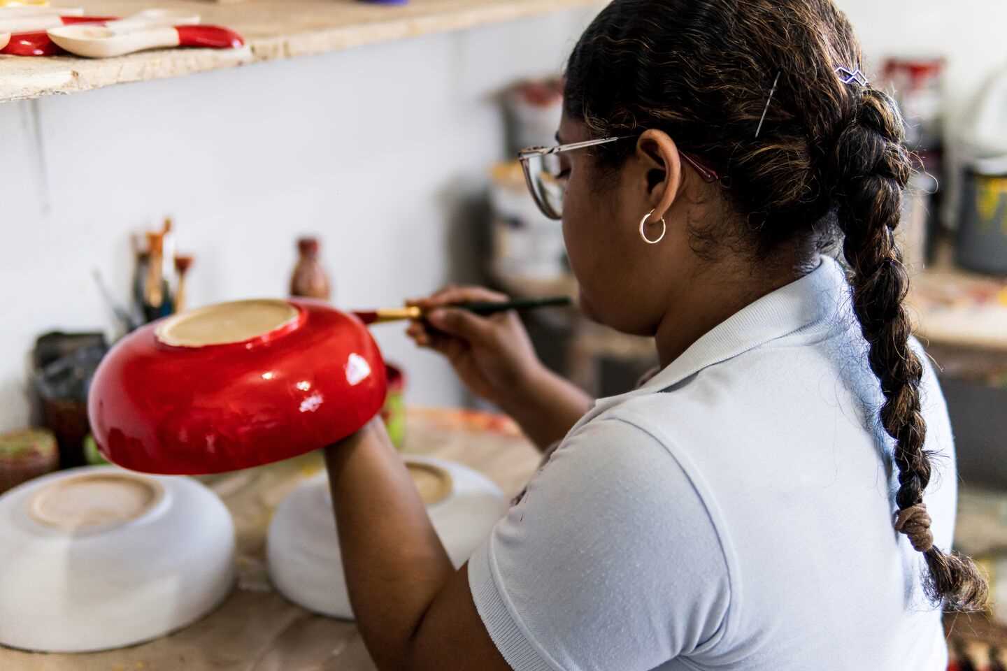 A artist painting a plate with brush in the cultural tradition of carnival of barranquilla Colombia