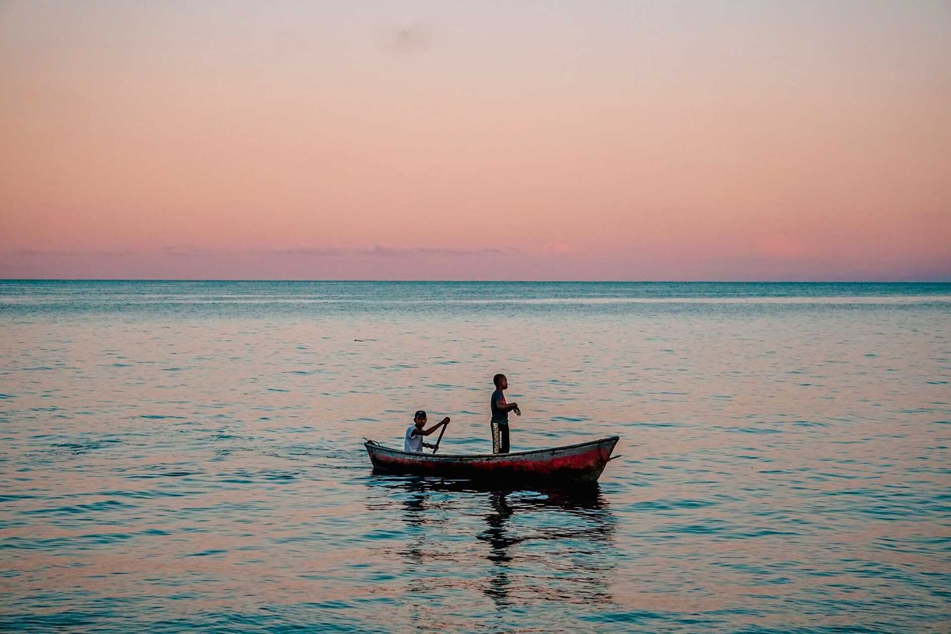 fishermen in a boat at sunset