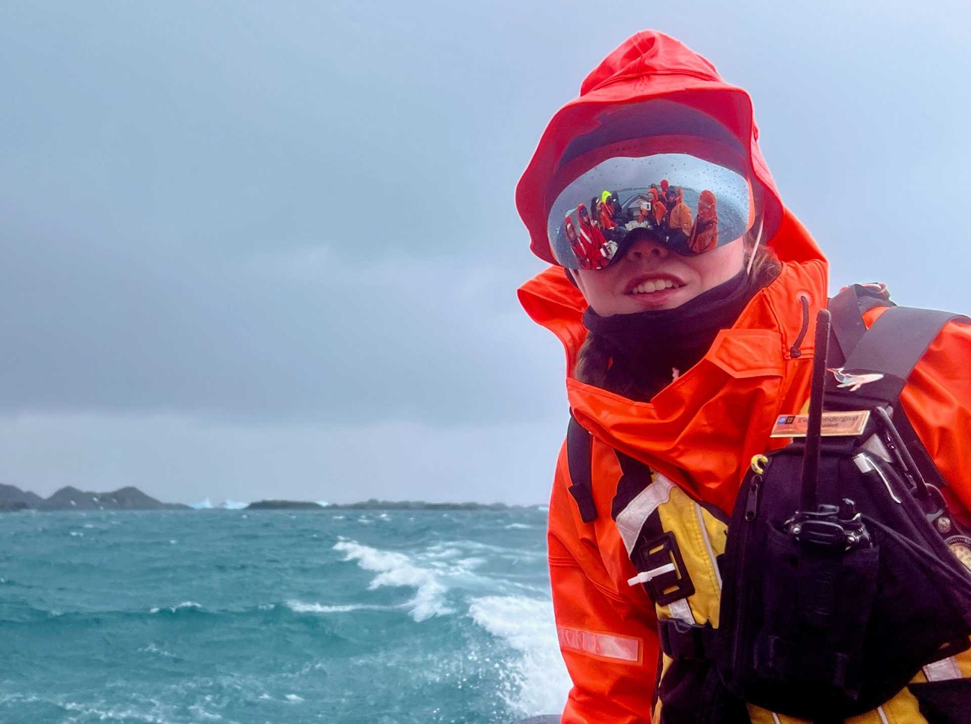 a woman in a red parka with mirrored sunglasses