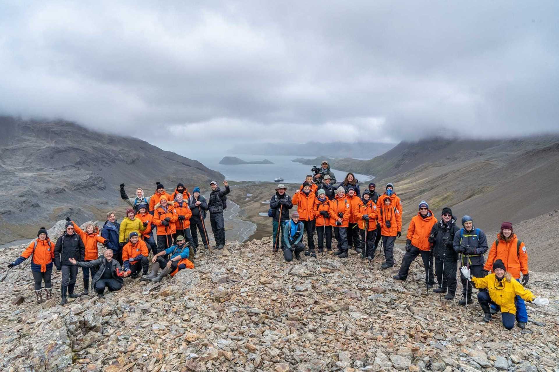 guests in orange parkas on top of a hill