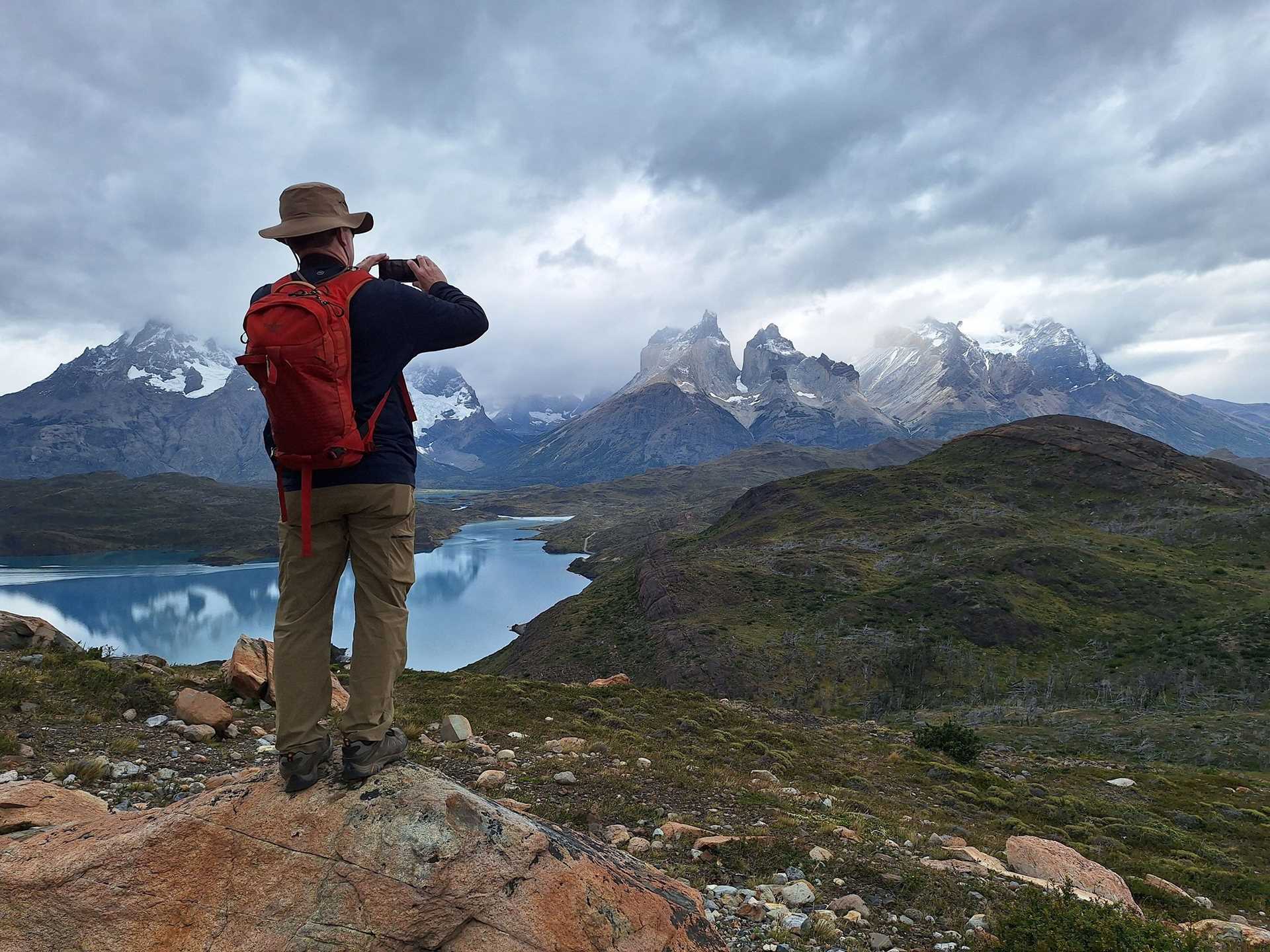 a man standing on a rock edge looking at mountains