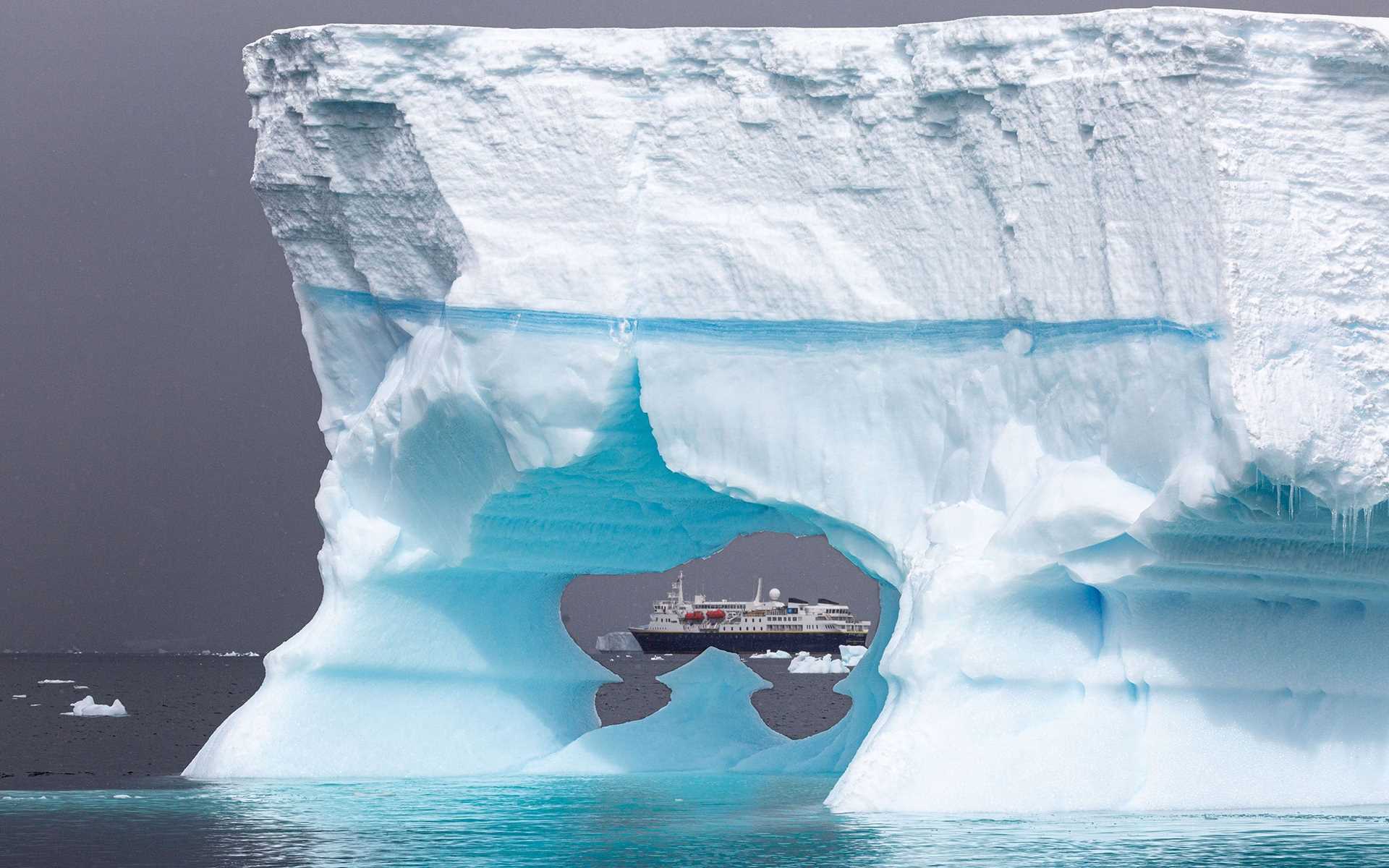 a large iceberg framing a ship