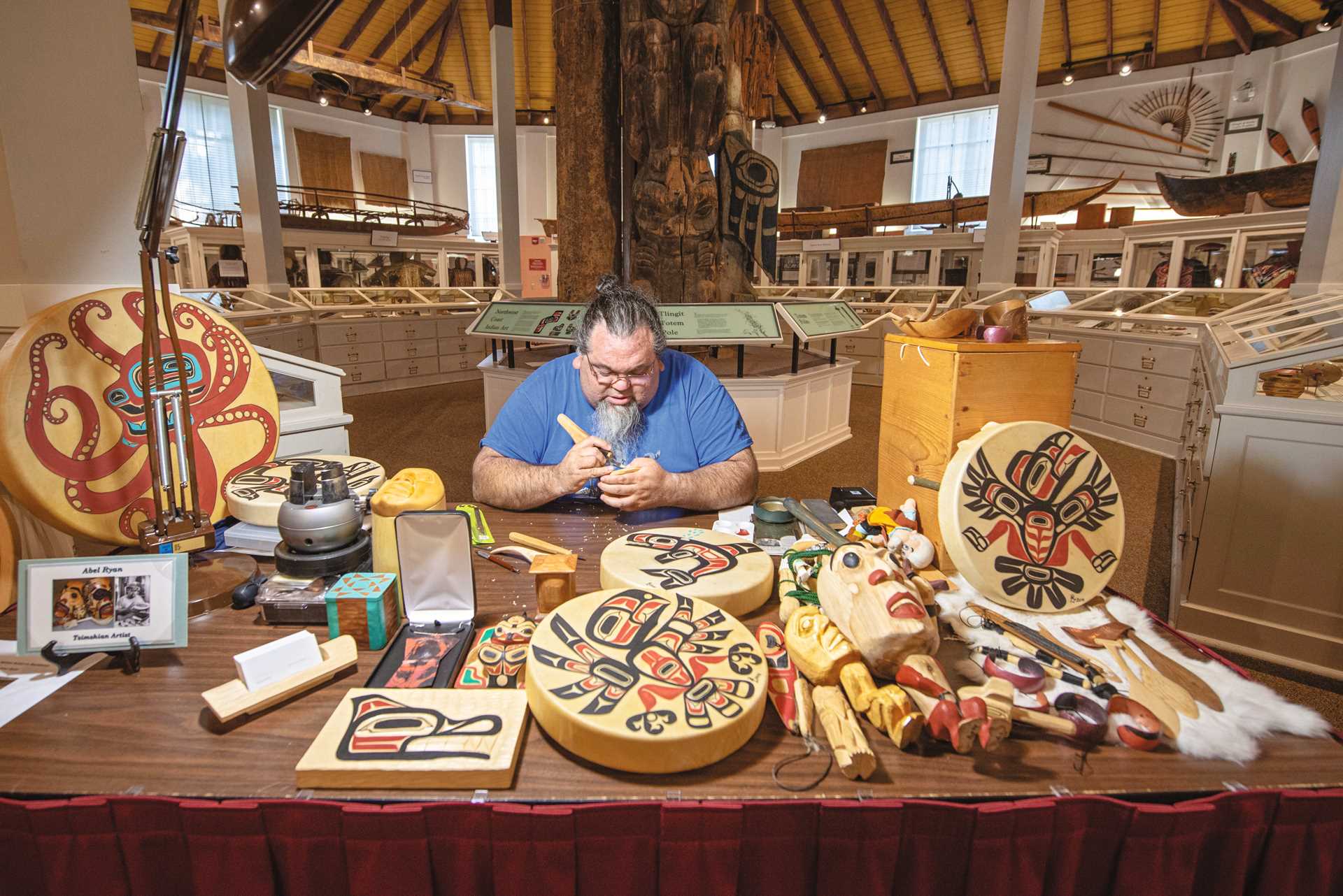 Artist in residence, Abel Ryan, demonstrates carving at the Sheldon Jackson Museum in Sitka, Alaska.