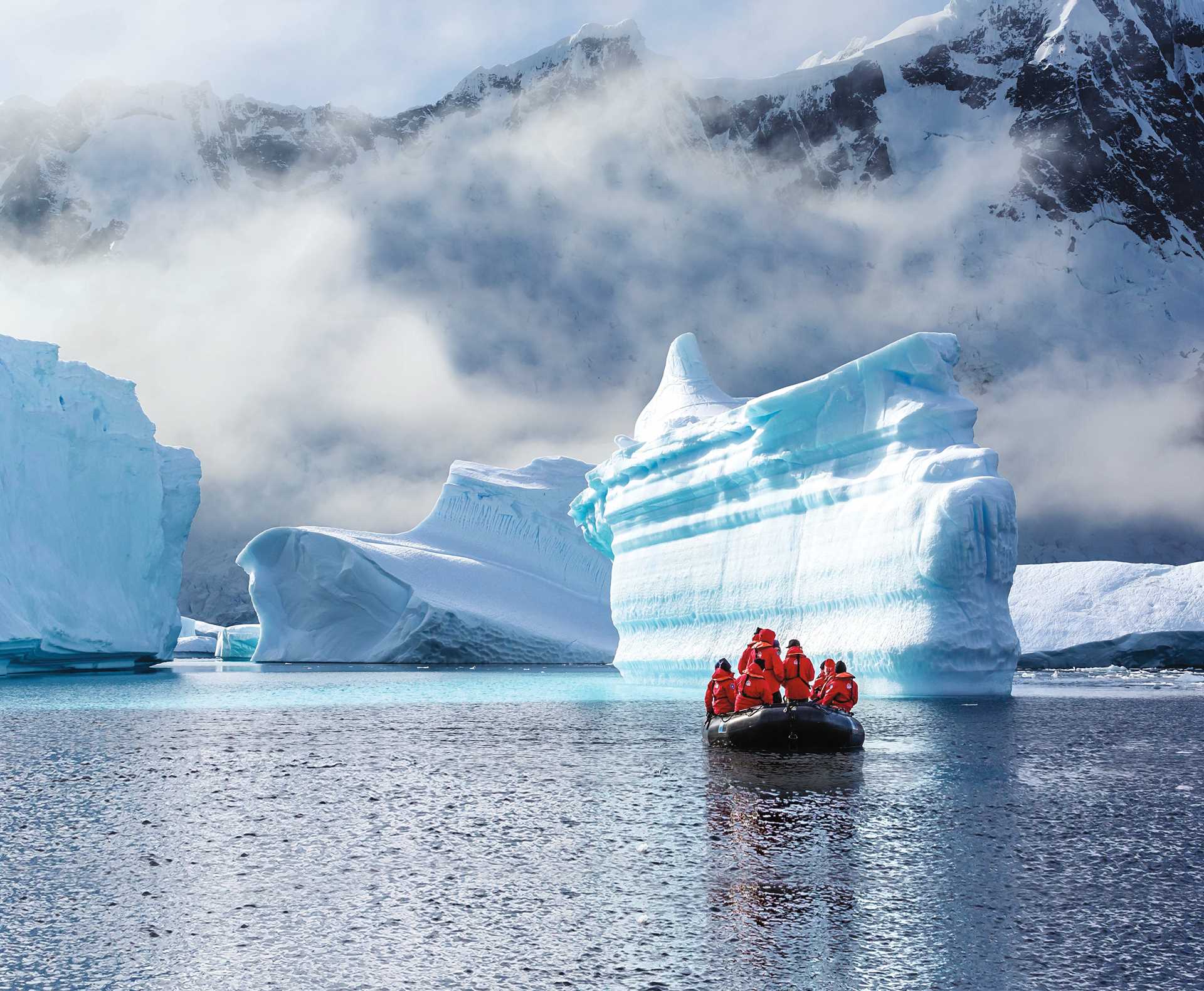 Travelers in a Zodiac off Booth Island look at four iridescent glaciers.