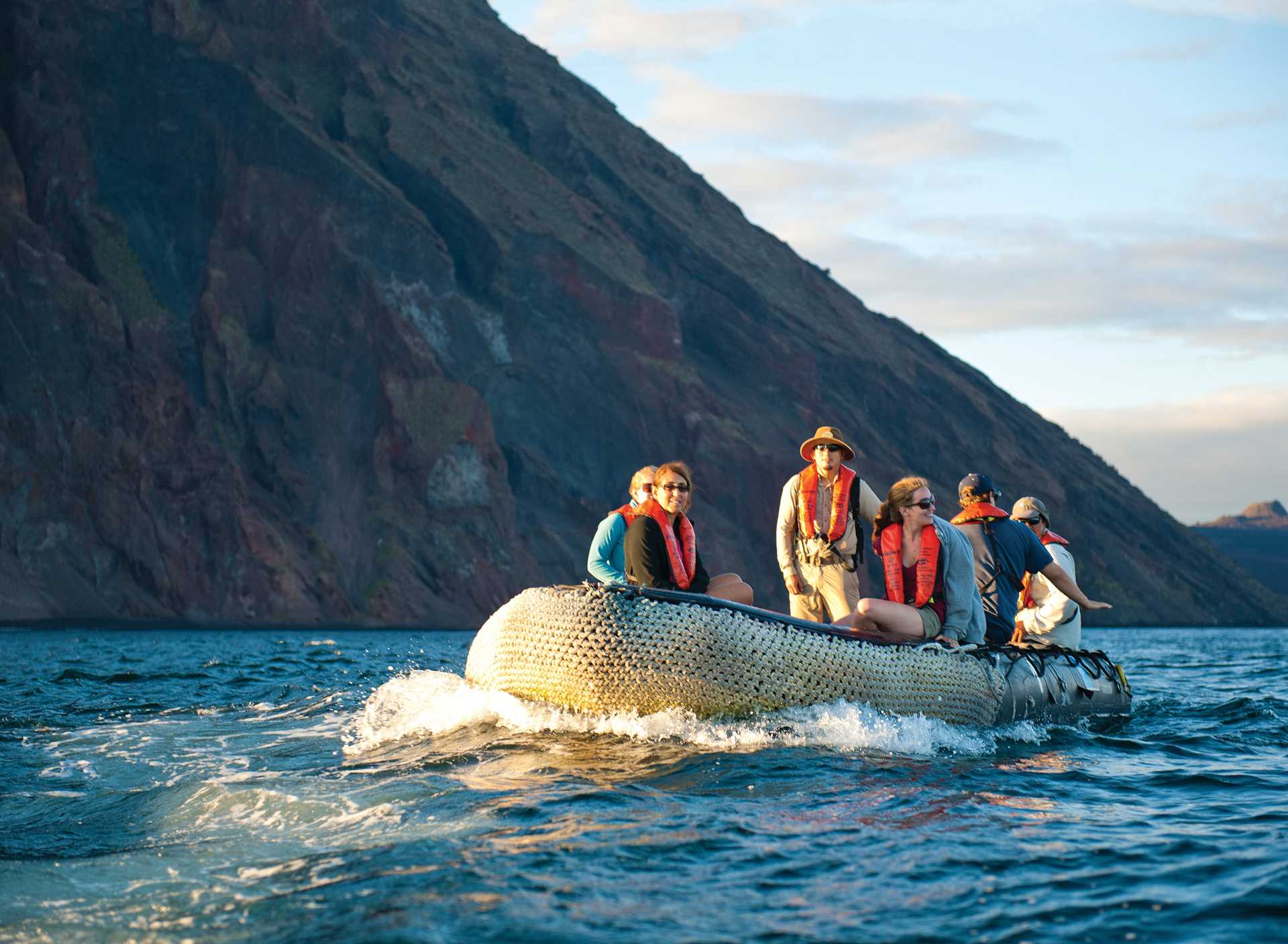 Five guests ride on a Zodiac driven by a naturalist, Galápagos.